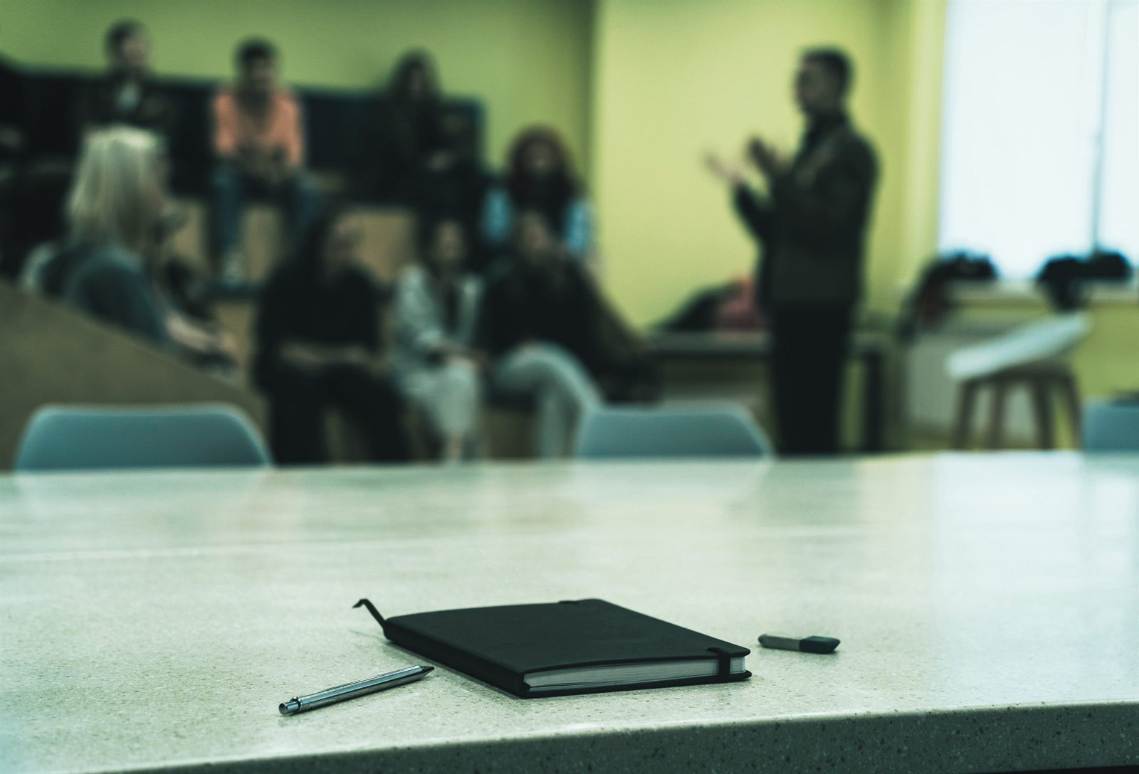A VOTAI facilitator leading a group training session, with a notebook ready on the table